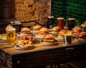 a table full of burgers and craft beers
